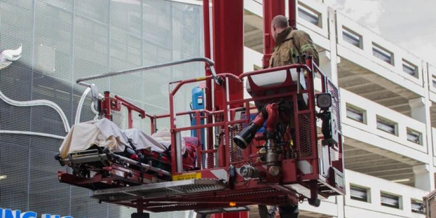 Ambulancemedewerkers met patient vast in lift