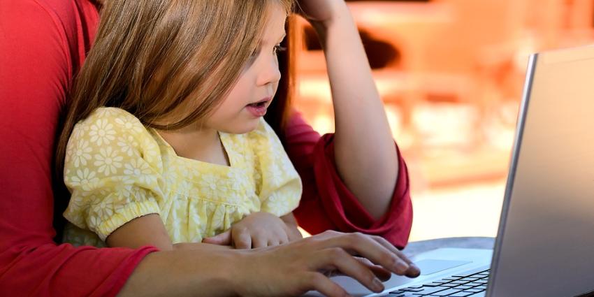 Kind met ouder achter laptop Kind met ouder achter laptop