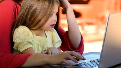 Kind met ouder achter laptop Kind met ouder achter laptop