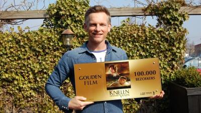 Knielen op een bed violen verwelkomt 100.000e bezoeker 